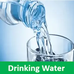 Clear water pouring from a plastic bottle into a clean glass