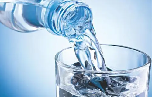 Clear bottled water pouring into a glass