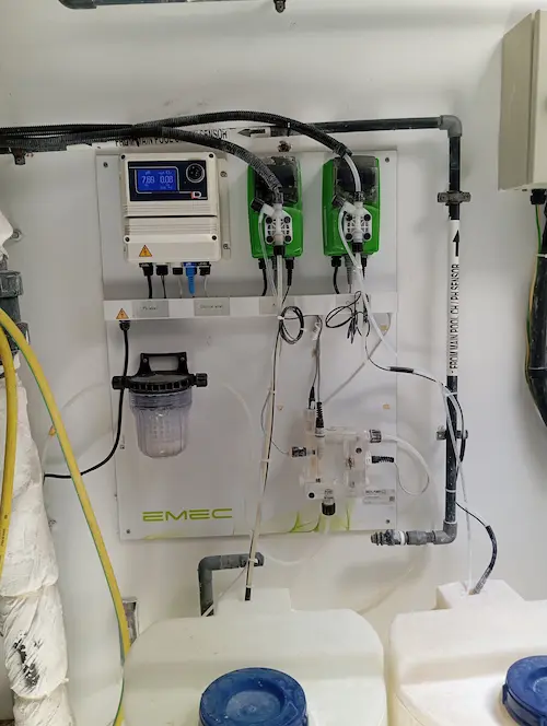 Cooling water treatment controller in operation, managing automated dosing pumps and chemical storage tanks.