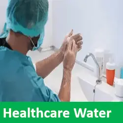 A surgeon scrubbing hands at a sink in a sterile washroom for hospital water treatment
