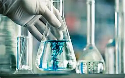 A conical flask filled with a bright blue chemical