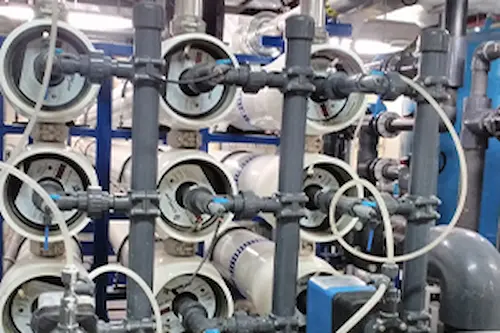 Side view of an industrial nanofiltration system showcasing the high-pressure membrane housings and stainless steel piping connections.