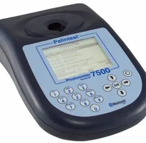 Handheld digital photometer being used to test water quality parameters in a laboratory setting.