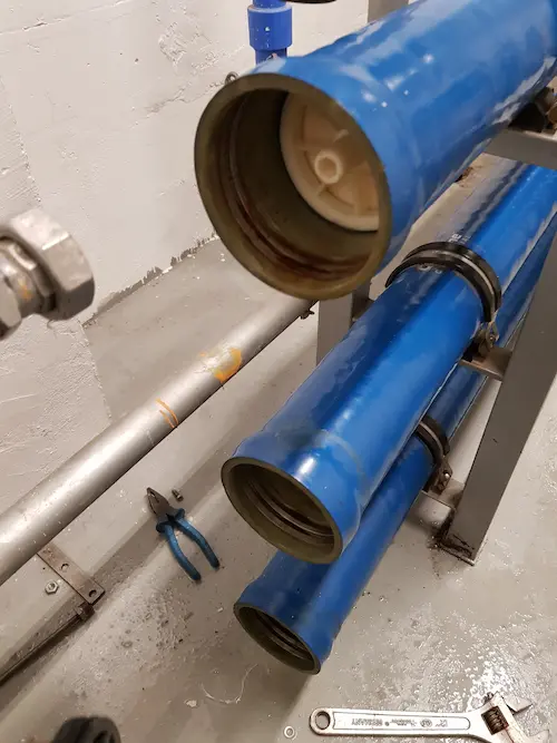 An open industrial reverse osmosis pressure vessel housing during a membrane replacement service