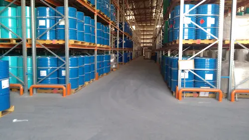 Industrial water treatment chemical warehouse showing rows of staged chemical drums from a certified supplier.