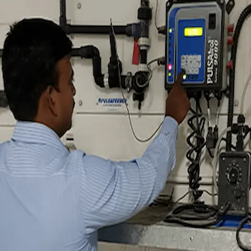 Water treatment engineer programming a digital control panel during a system commissioning.